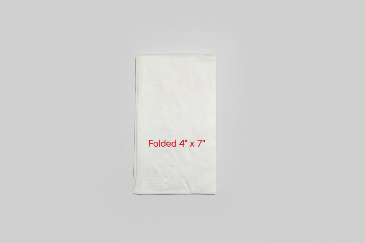 White folded paper with dimensions 4" x 7" on a brown surface with a ruler.